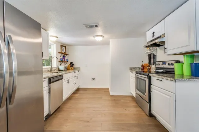a kitchen with stainless steel appliances a refrigerator sink and stove