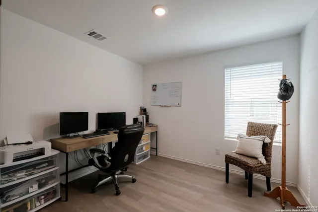 a view of a workspace with furniture and a window