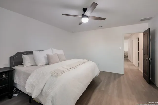 a bed room with a bed and a ceiling fan