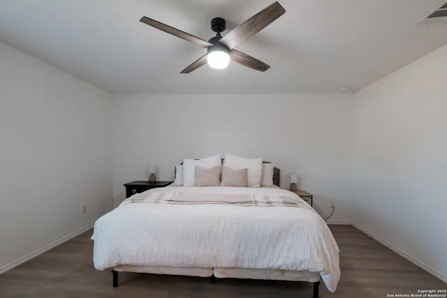 a bedroom with a bed and a ceiling fan