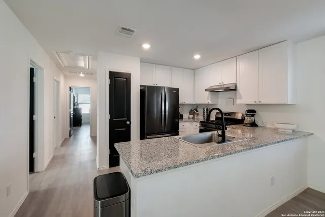 a kitchen with sink refrigerator and cabinets