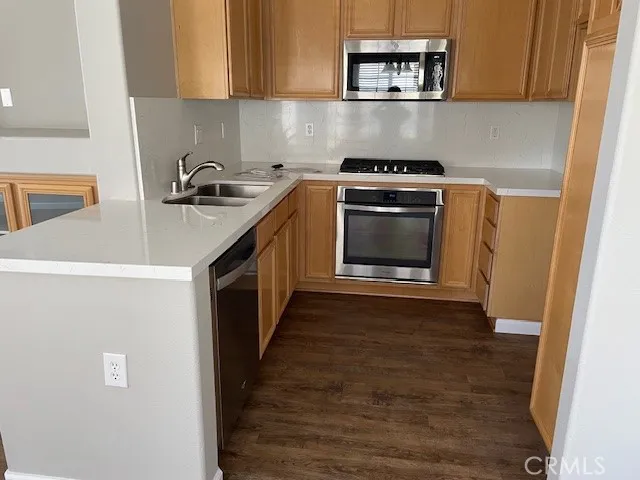 a kitchen with granite countertop a stove top oven a sink and dishwasher