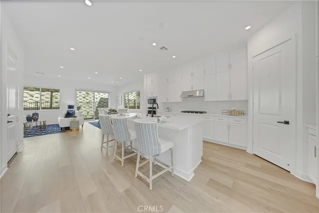 a kitchen with white cabinets and chairs