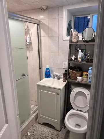 a bathroom with a granite countertop toilet sink and mirror
