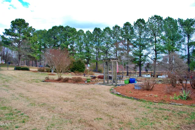 a view of a backyard with wooden fence and large trees