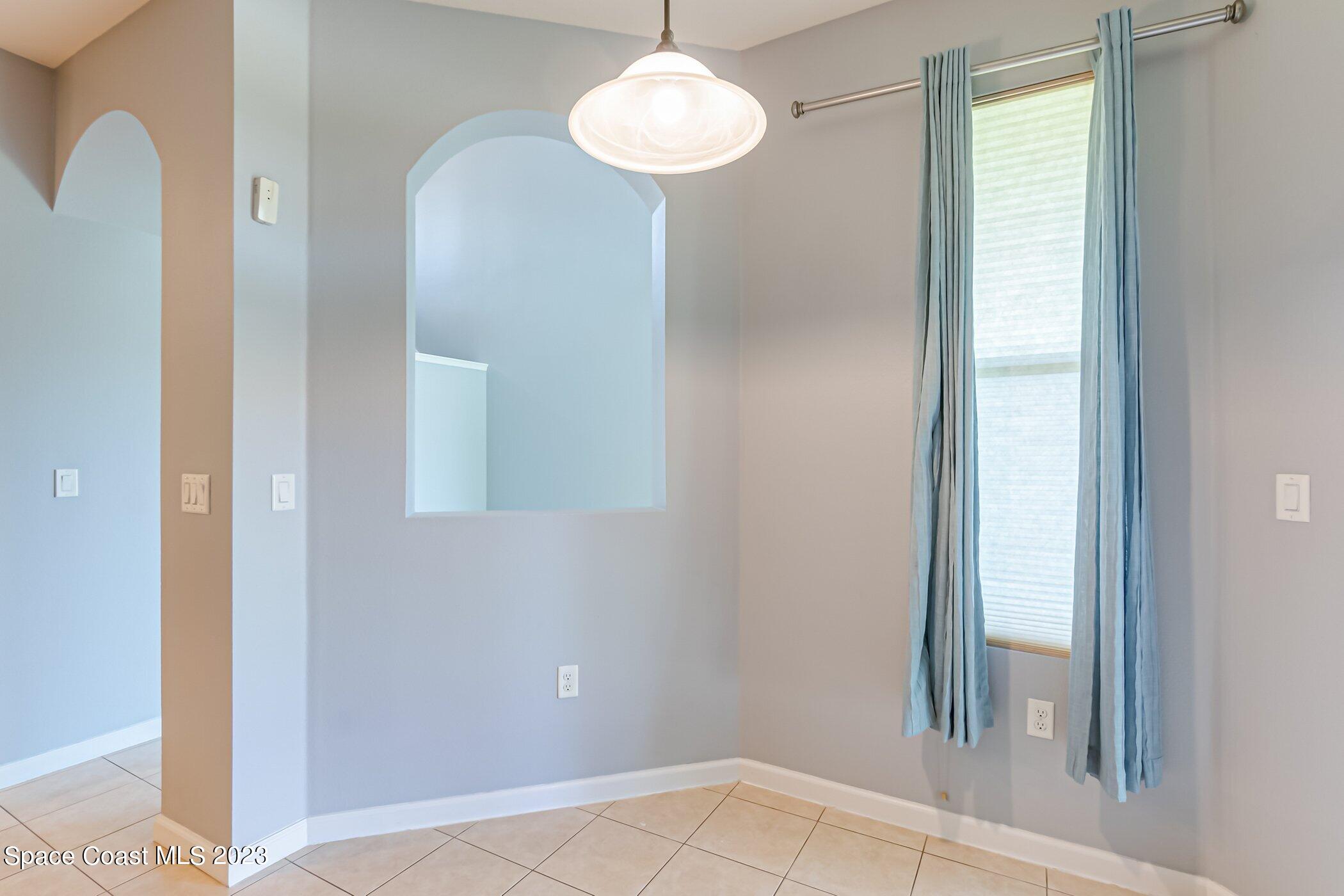 3194 Arden Circle Melbourne, FL 32934 - Photo 17 of 40 a view of a hallway with a chandelier fan and windows