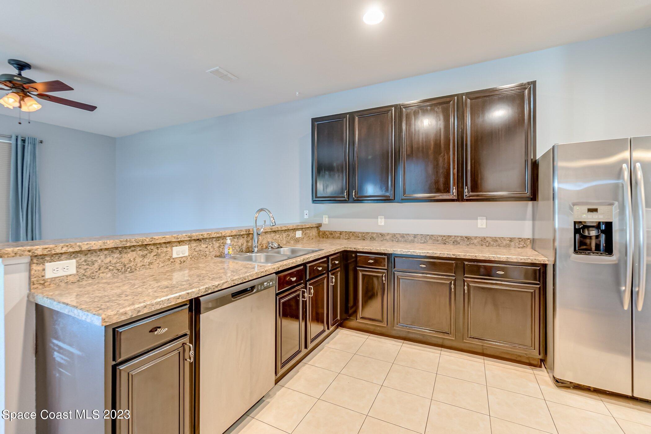 3194 Arden Circle Melbourne, FL 32934 - Photo 21 of 40 a kitchen with stainless steel appliances granite countertop a sink stove and refrigerator