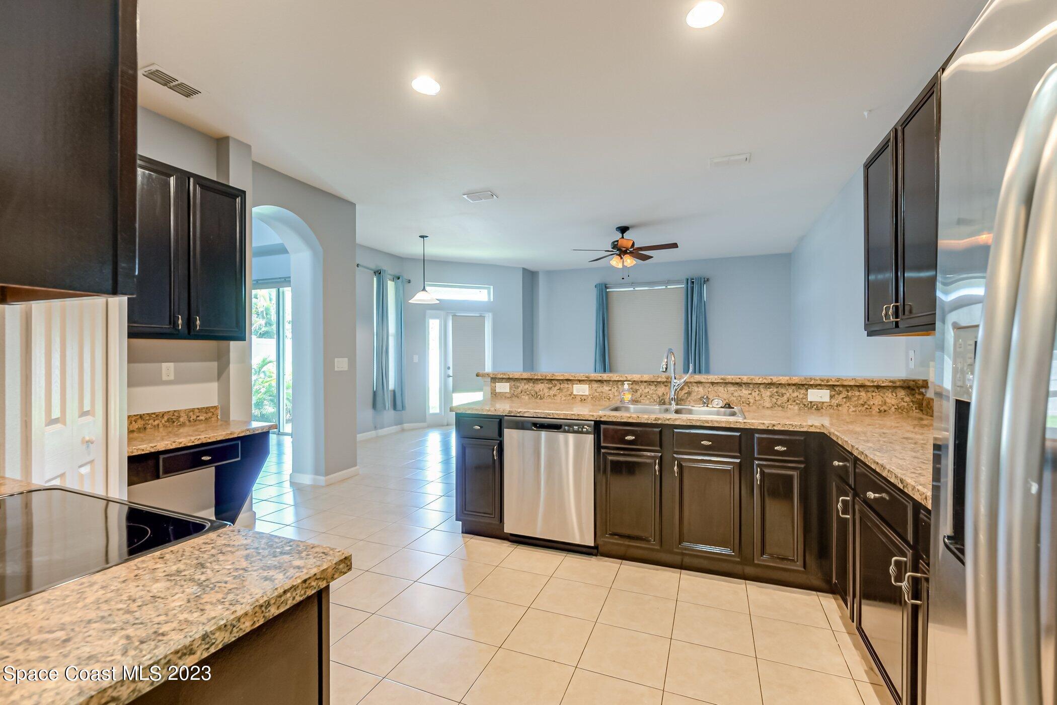 3194 Arden Circle Melbourne, FL 32934 - Photo 23 of 40 a large kitchen with stainless steel appliances granite countertop a stove and a sink