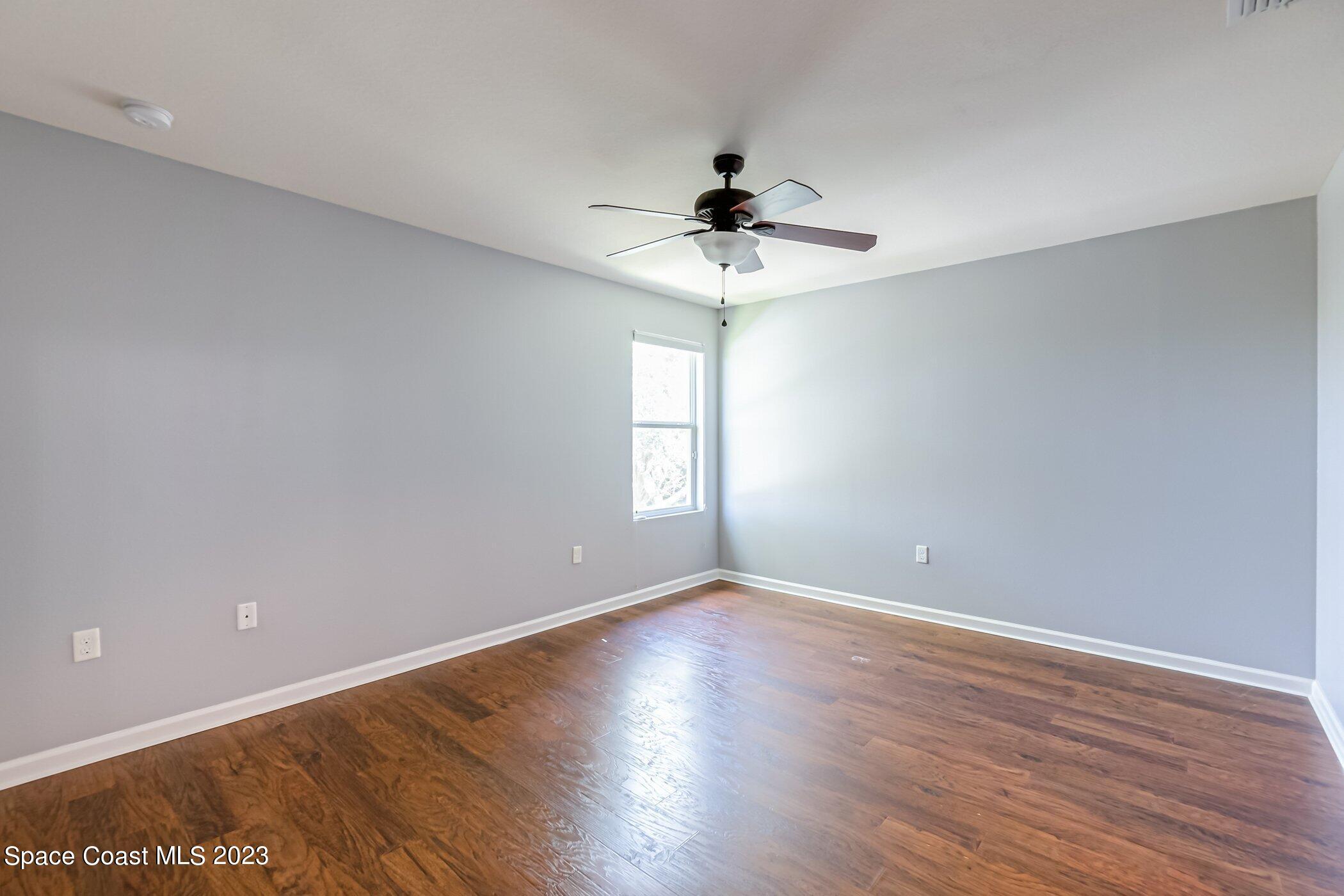 3194 Arden Circle Melbourne, FL 32934 - Photo 26 of 40 a view of an empty room with wooden floor and a window