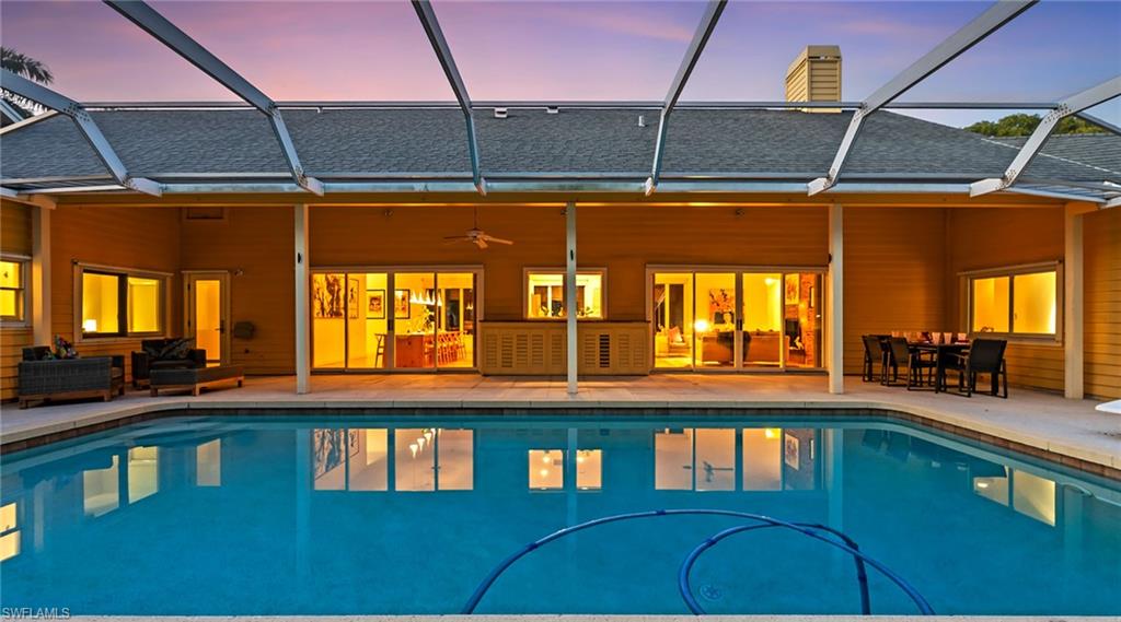 586 Yucca Road Naples, FL 34102 - Photo 21 of 26 Swimming pool with a sunroom, a lanai, a patio, and outdoor dining area
