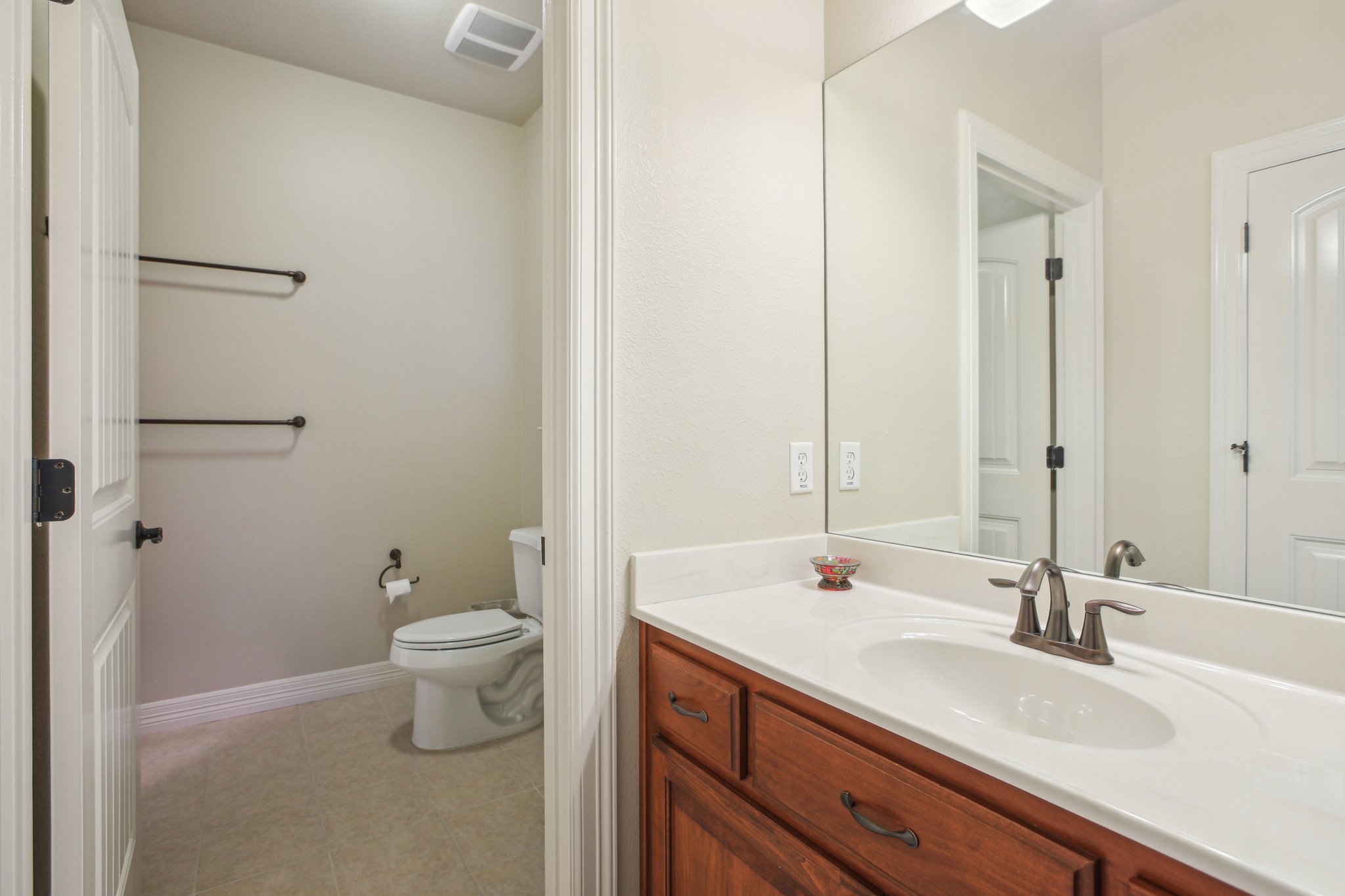 600 Augusta Circle Point Venture, TX 78645 - Photo 25 of 38 a bathroom with a double vanity sink toilet and a mirror