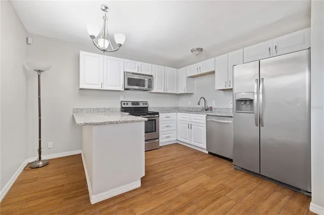 a kitchen with white cabinets and stainless steel appliances
