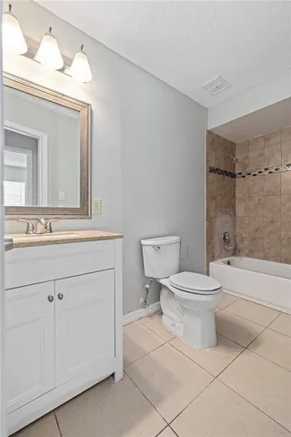 a bathroom with a toilet a sink a mirror and bathtub
