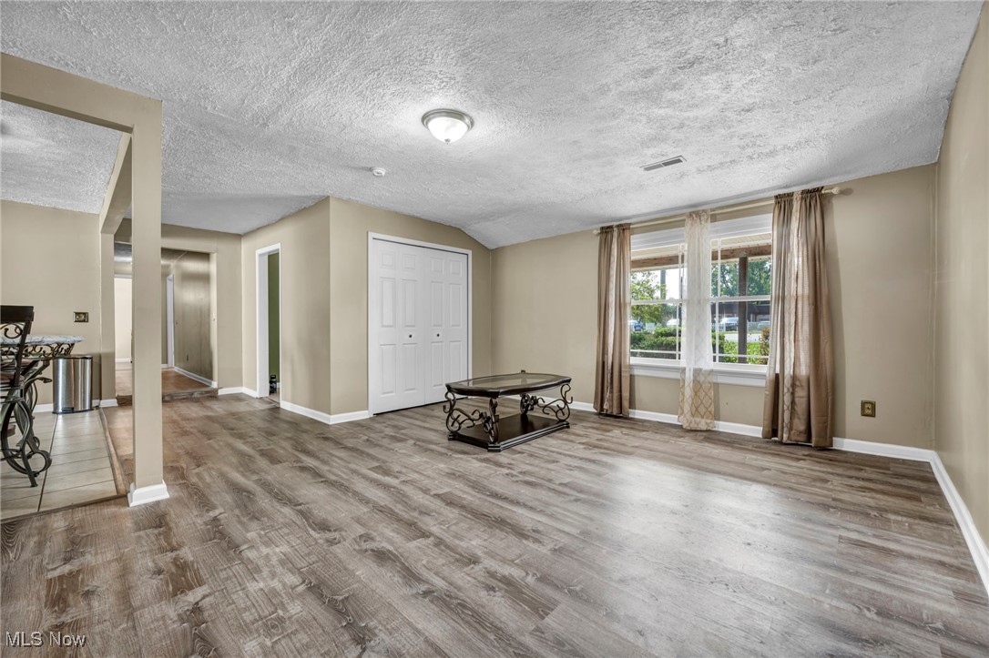 39020 Center Ridge Road North Ridgeville, OH 44039 - Photo 12 of 30 Living room featuring hardwood / wood-style floors, vaulted ceiling, and a textured ceiling