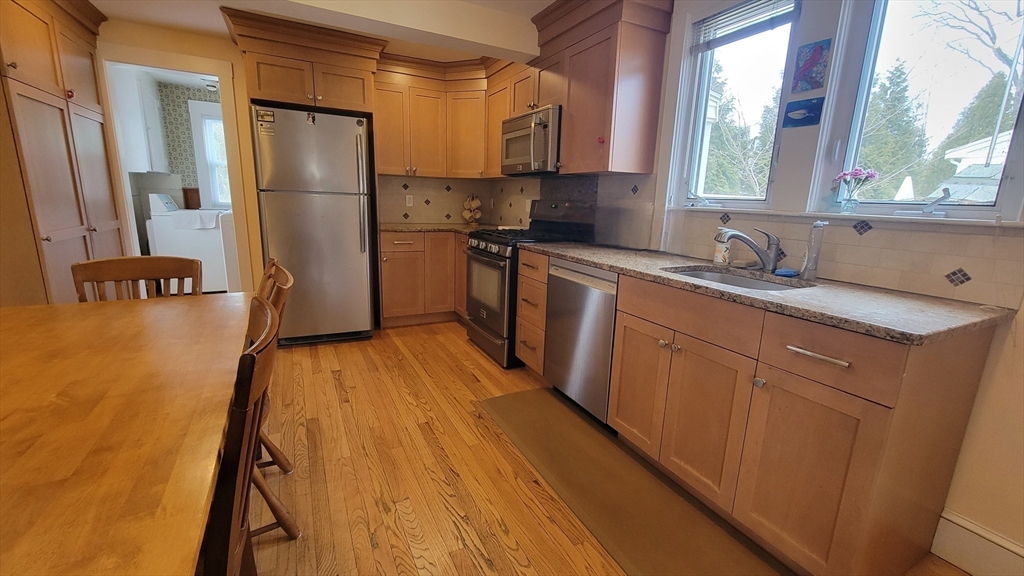 31 Plymouth Road Needham, MA 02492 - Photo 7 of 22 a kitchen with granite countertop a refrigerator a sink a stove and cabinets