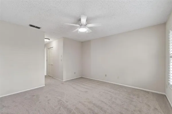 an empty room with a ceiling fan and a fan