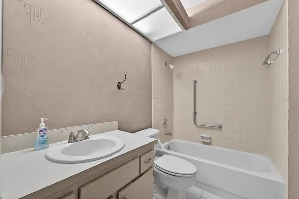 a bathroom with a granite countertop sink a toilet and a bathtub