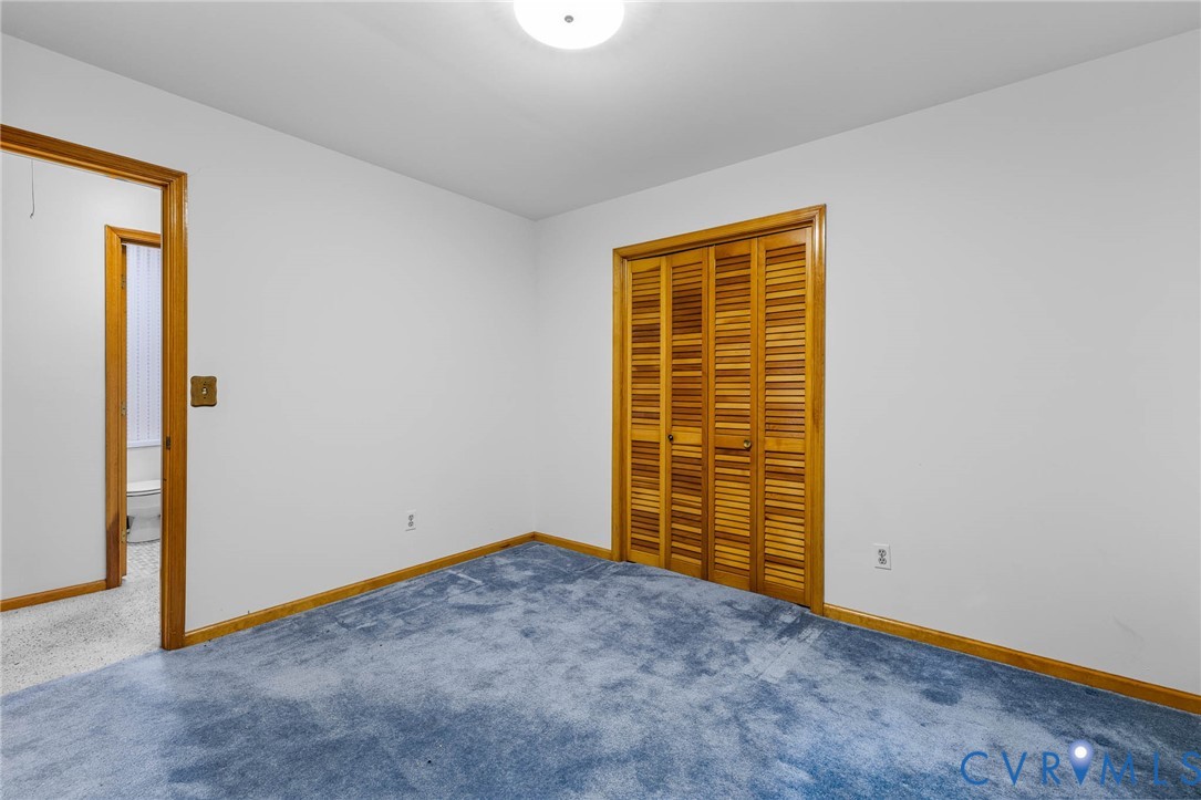 24925 Smith Grove Road Petersburg, VA 23803 - Photo 18 of 19 Unfurnished bedroom featuring carpet and a closet
