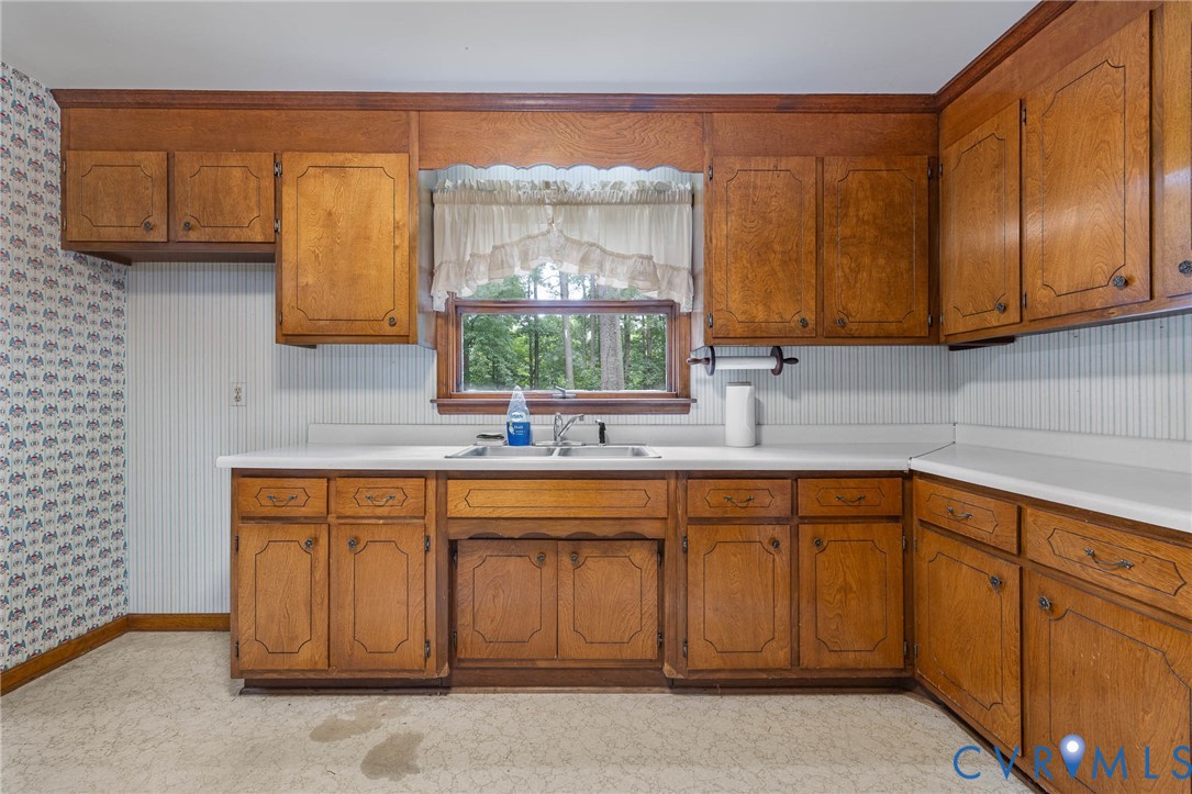24925 Smith Grove Road Petersburg, VA 23803 - Photo 6 of 19 Kitchen featuring brown cabinets, wallpapered wall