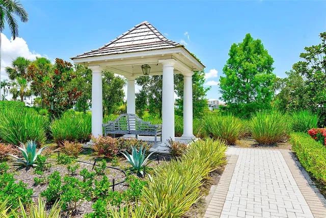 a view of a white house with a yard and potted plants