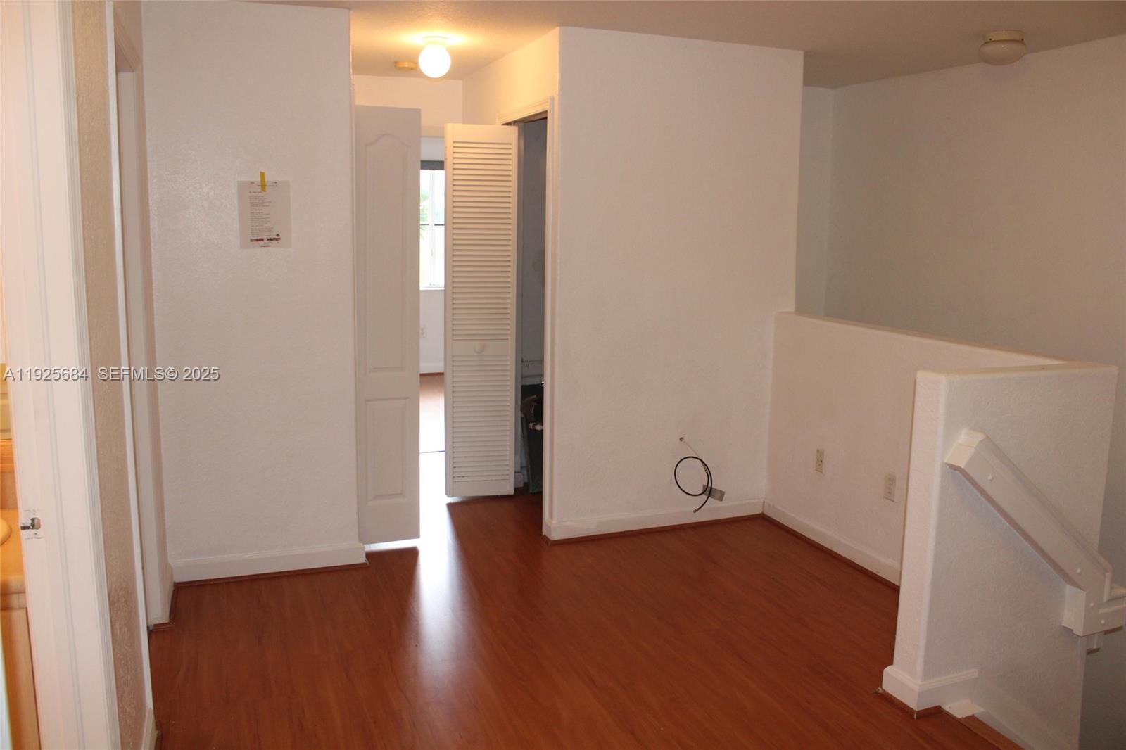 3433 Southwest 171st Terrace, Unit 3433 Miramar, FL 33027 - Photo 15 of 22 a view of an empty room with wooden floor and a window