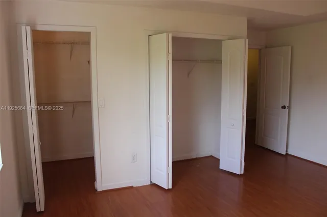 an empty room with wooden floor and closet