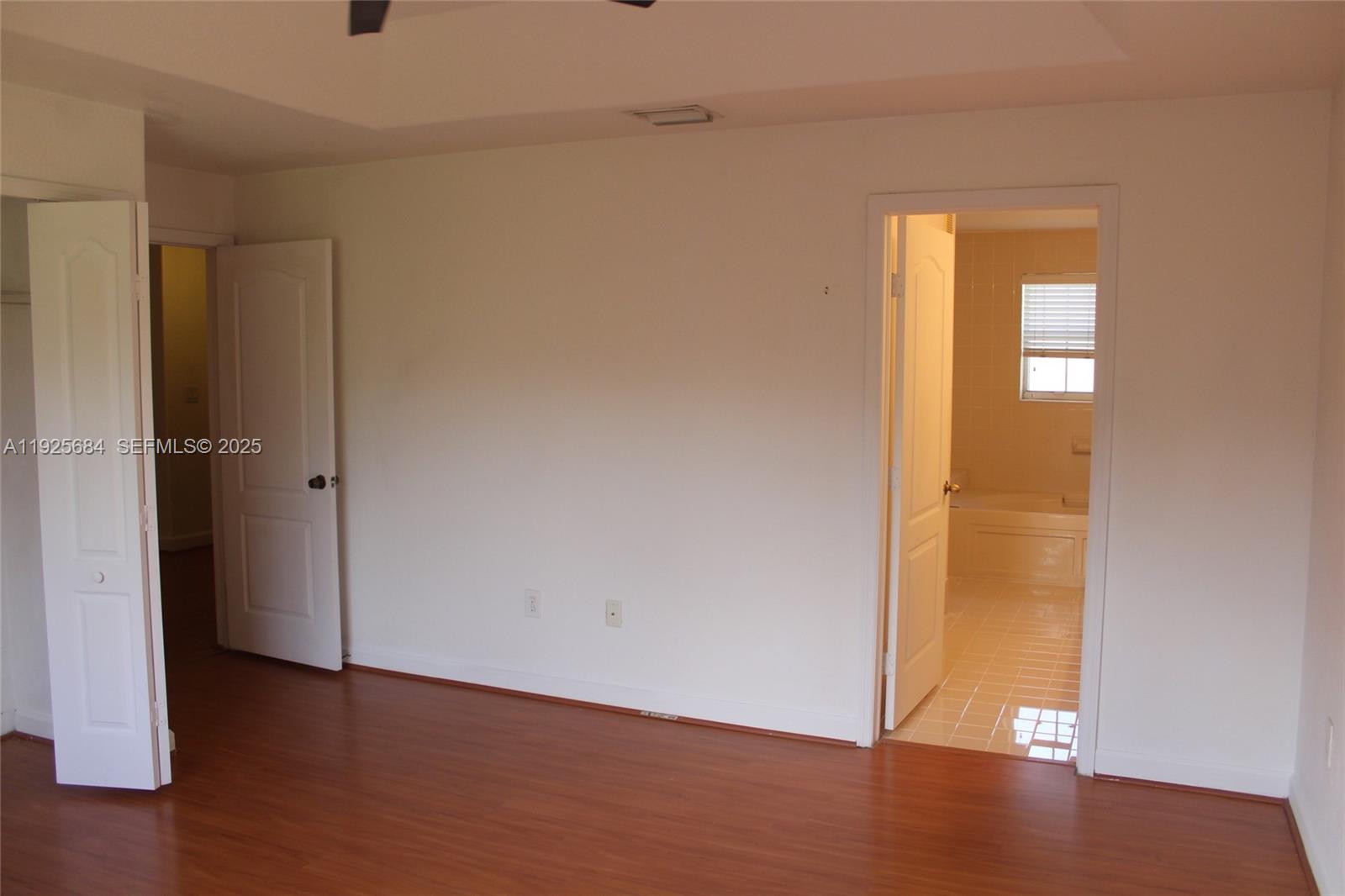 3433 Southwest 171st Terrace, Unit 3433 Miramar, FL 33027 - Photo 18 of 22 an empty room with wooden floor and windows