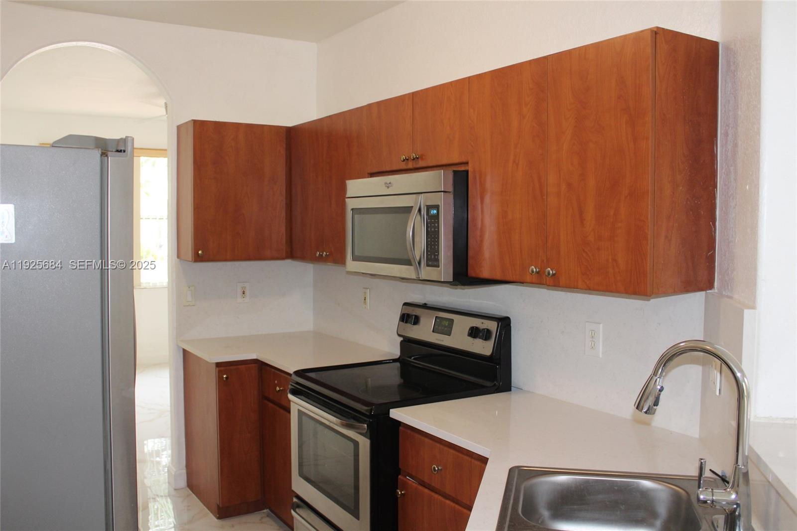 3433 Southwest 171st Terrace, Unit 3433 Miramar, FL 33027 - Photo 2 of 22 a kitchen with stainless steel appliances granite countertop a stove top oven a sink and dishwasher