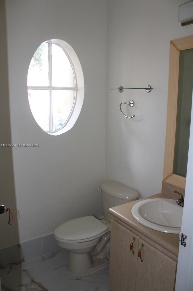3433 Southwest 171st Terrace, Unit 3433 Miramar, FL 33027 - Photo 5 of 22 a white toilet sitting next to a window