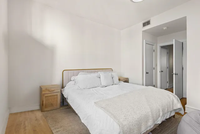 a large bed sitting in a bedroom and a table