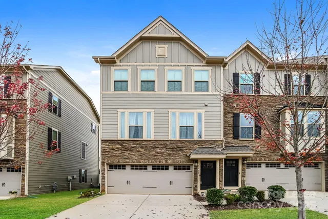 a view of a brick house with many windows and a yard