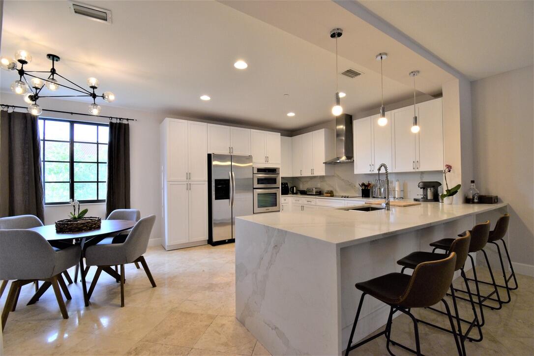 4866 Northwest 16th Avenue Boca Raton, FL 33431 - Photo 1 of 67 a kitchen with a dining table chairs and refrigerator