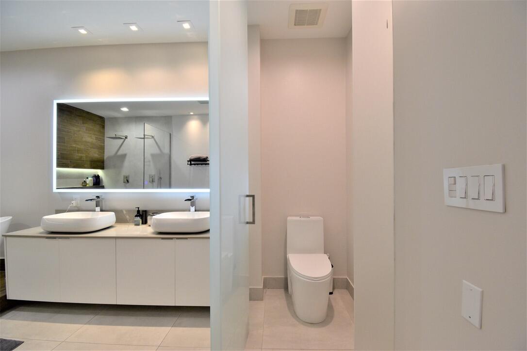 4866 Northwest 16th Avenue Boca Raton, FL 33431 - Photo 46 of 67 a bathroom with a toilet sink and mirror