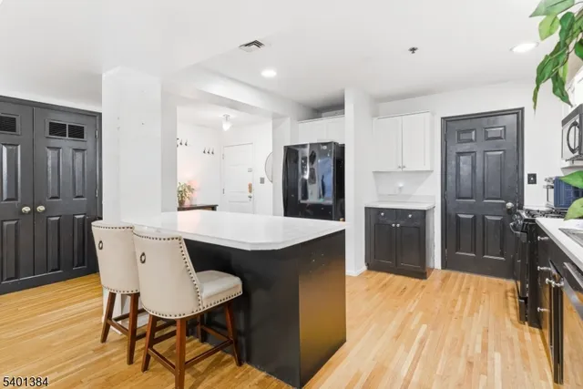a kitchen with stainless steel appliances a dining table chairs and wooden floor