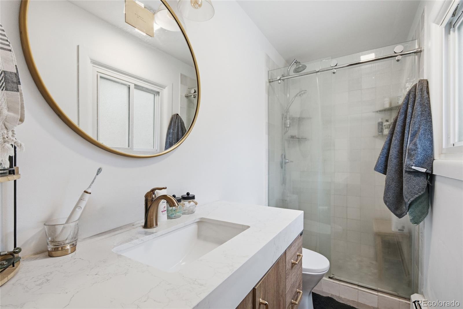6387 High Drive Morrison, CO 80465 - Photo 28 of 49 a bathroom with a sink a toilet and a mirror