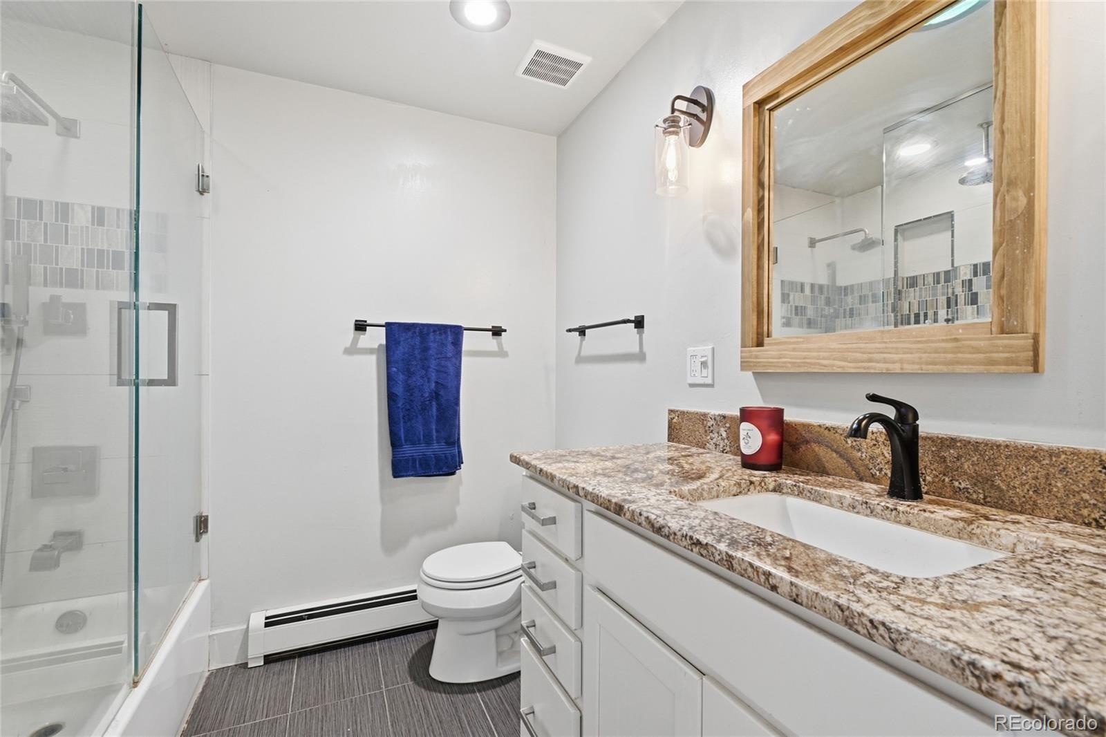 6387 High Drive Morrison, CO 80465 - Photo 31 of 49 a bathroom with a granite countertop sink toilet and shower
