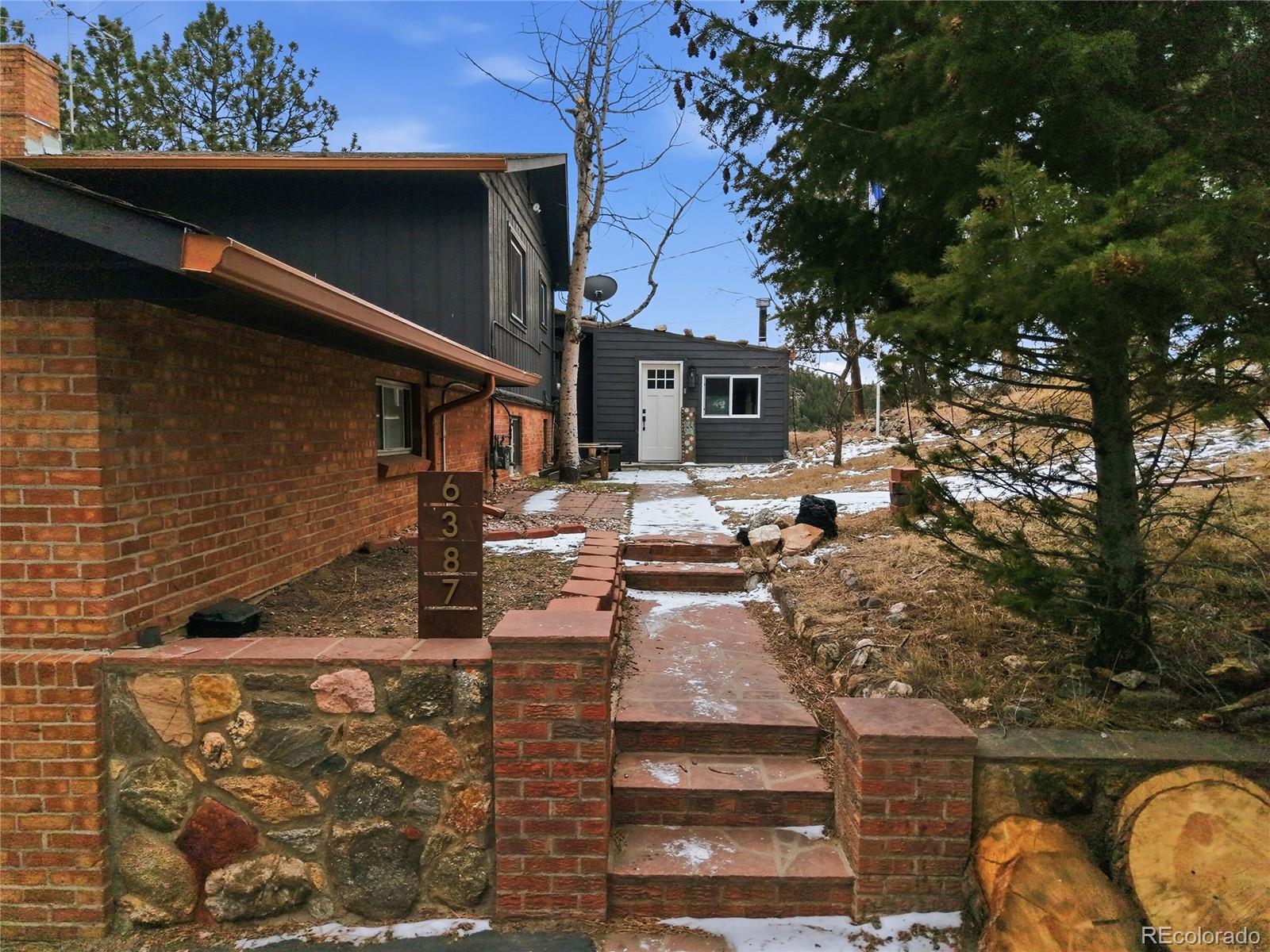 6387 High Drive Morrison, CO 80465 - Photo 44 of 49 a view of a patio with table and chairs with wooden fence and plants