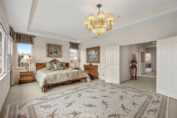 a bedroom with a bed and a chandelier