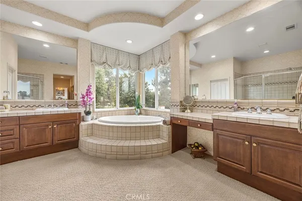a bathroom with a granite countertop sink mirror and bathtub