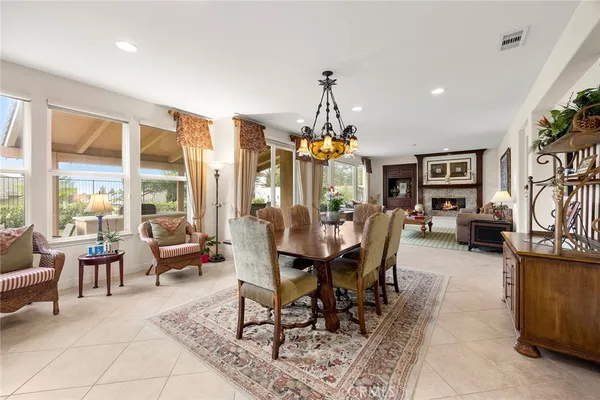 a living room with furniture a chandelier and a dining table