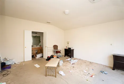 a living room with furniture a flat screen tv and a refrigerator