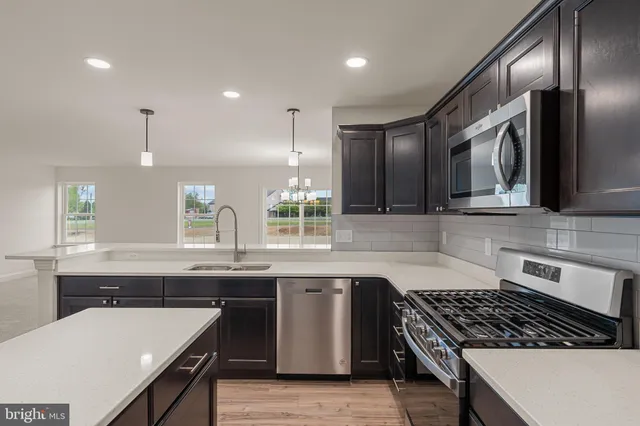 a kitchen with stainless steel appliances granite countertop a sink a stove and a refrigerator