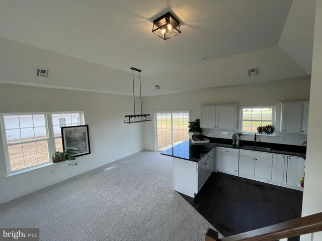 a kitchen with granite countertop a stove sink and microwave