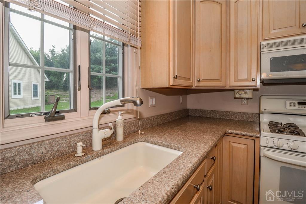 33 Whitehall Road Monroe Township, NJ 08831 - Photo 14 of 25 a kitchen with granite countertop a sink and a stove top oven
