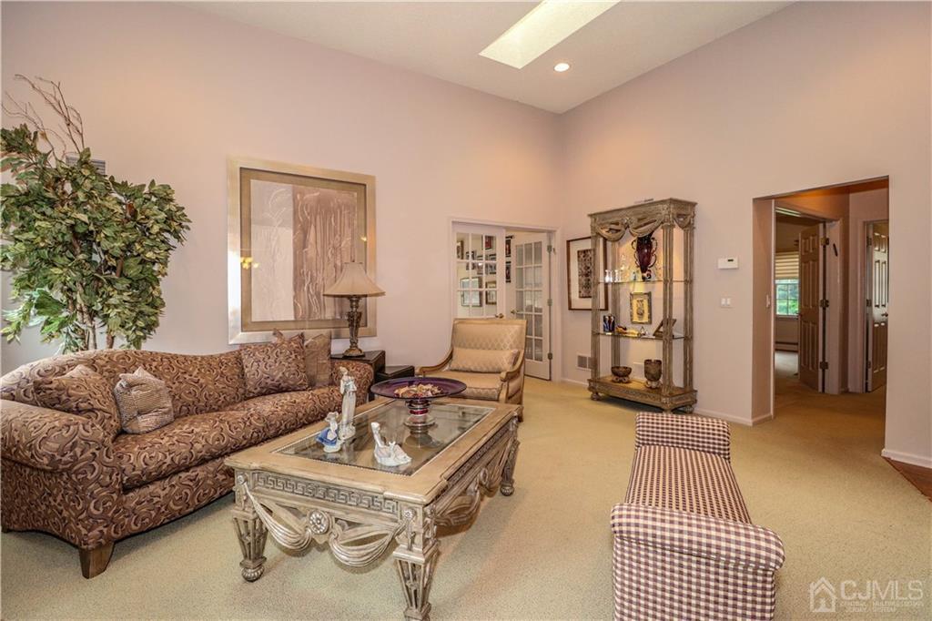 33 Whitehall Road Monroe Township, NJ 08831 - Photo 7 of 25 a living room with furniture a rug and a chandelier
