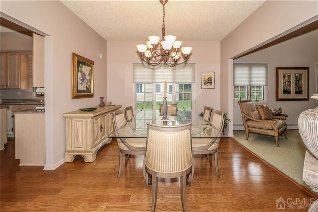 33 Whitehall Road Monroe Township, NJ 08831 - Photo 8 of 25 a view of a dining room with furniture a chandelier and wooden floor