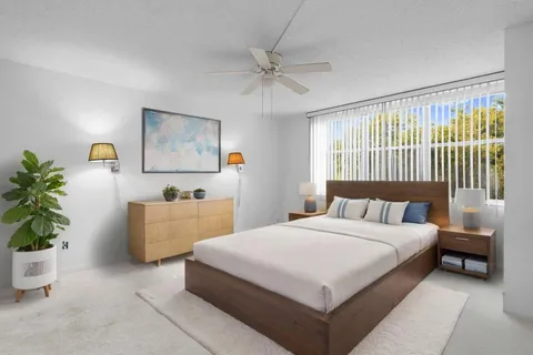 an empty room with windows and ceiling fan