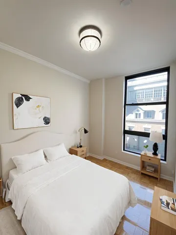 a bedroom with a bed and a large window