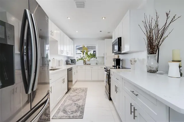a kitchen with white cabinets and stainless steel appliances