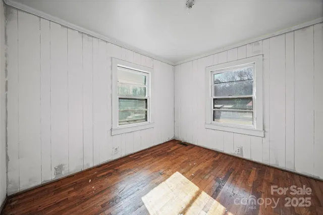 wooden floor in an empty room with a window